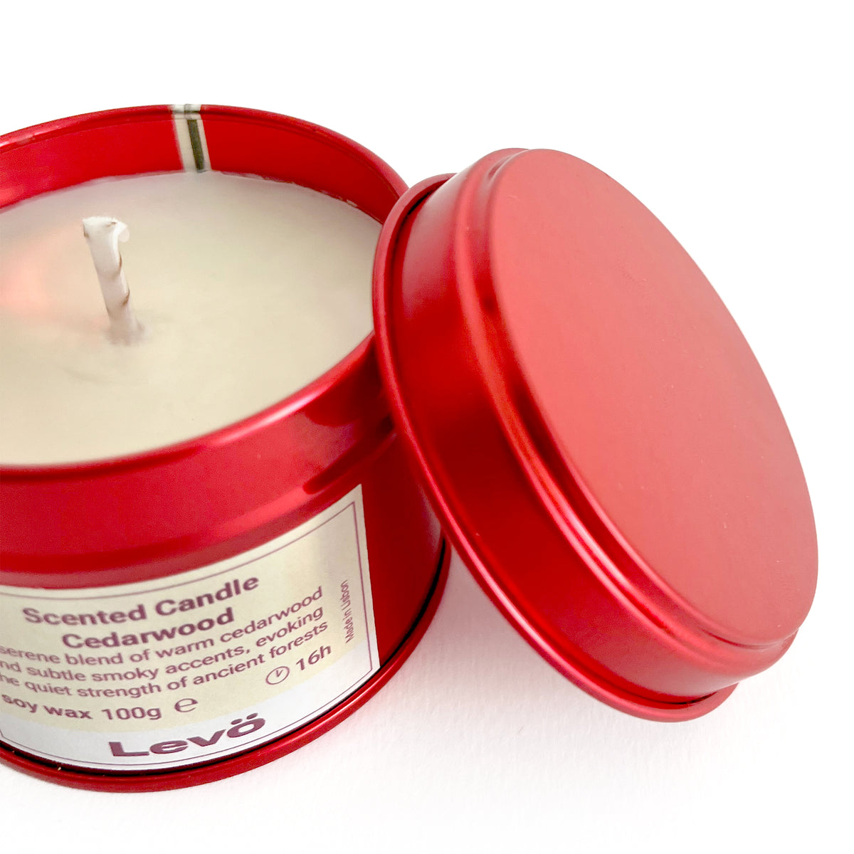 Scented candle in a red tin with a visible label on a white background