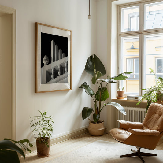 Modern living room with a brown armchair, plants, and a framed black and white photography art