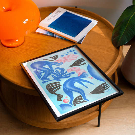 Limited edition riso poster in blue by Marvin Langner on the table in a living room