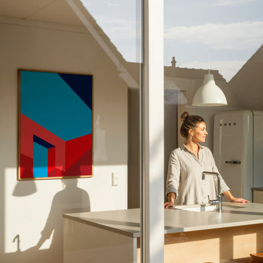 Woman standing in a modern kitchen with a colorful abstract poster on the wall.