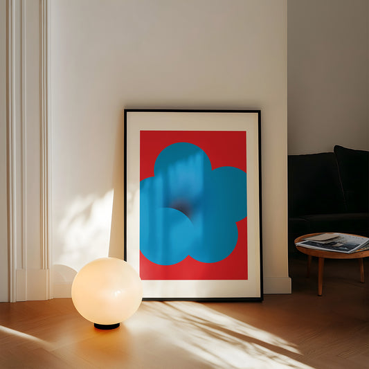 Framed abstract art with blue and red design in a living room setting.