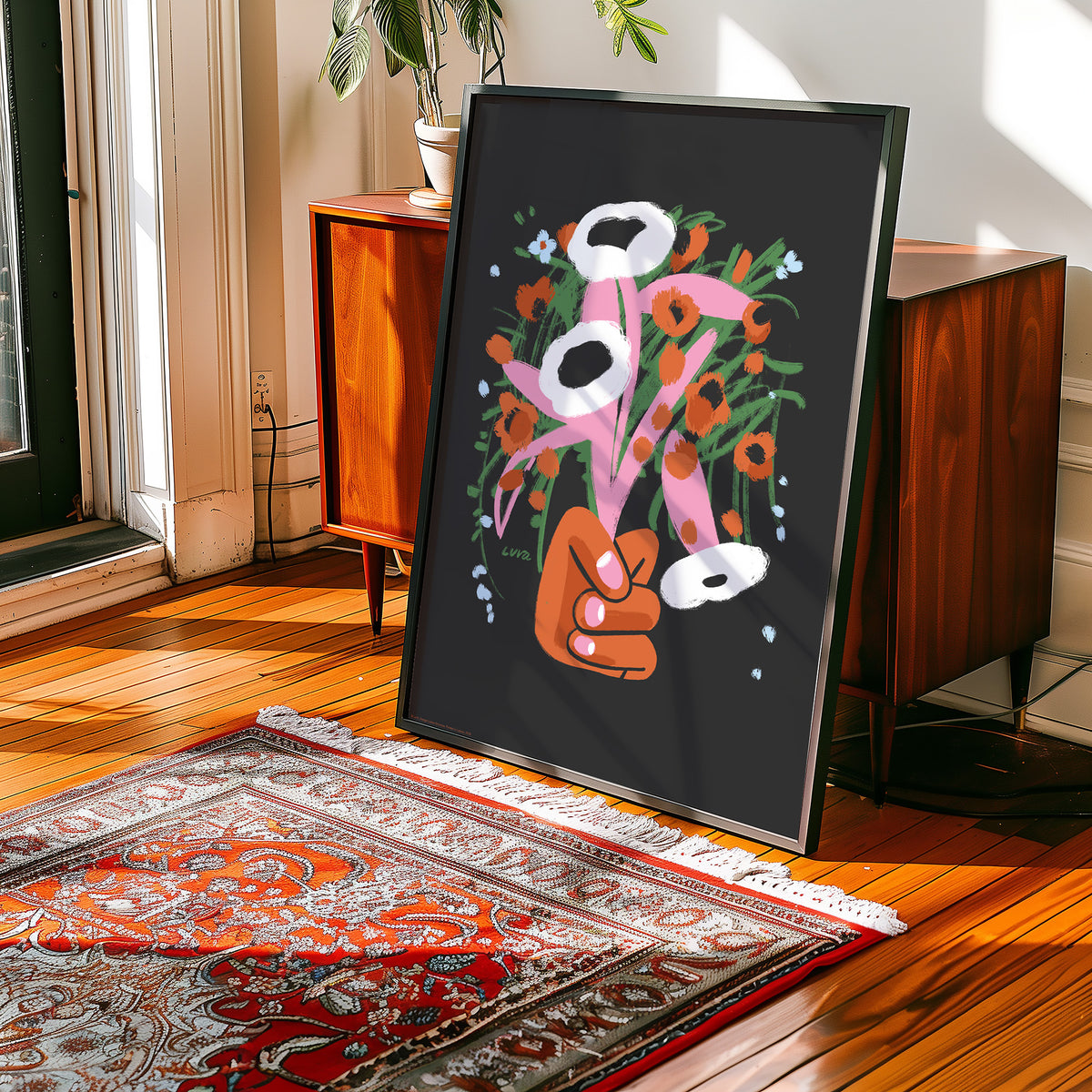 Framed artwork of a hand holding flowers on a wooden floor with a rug.