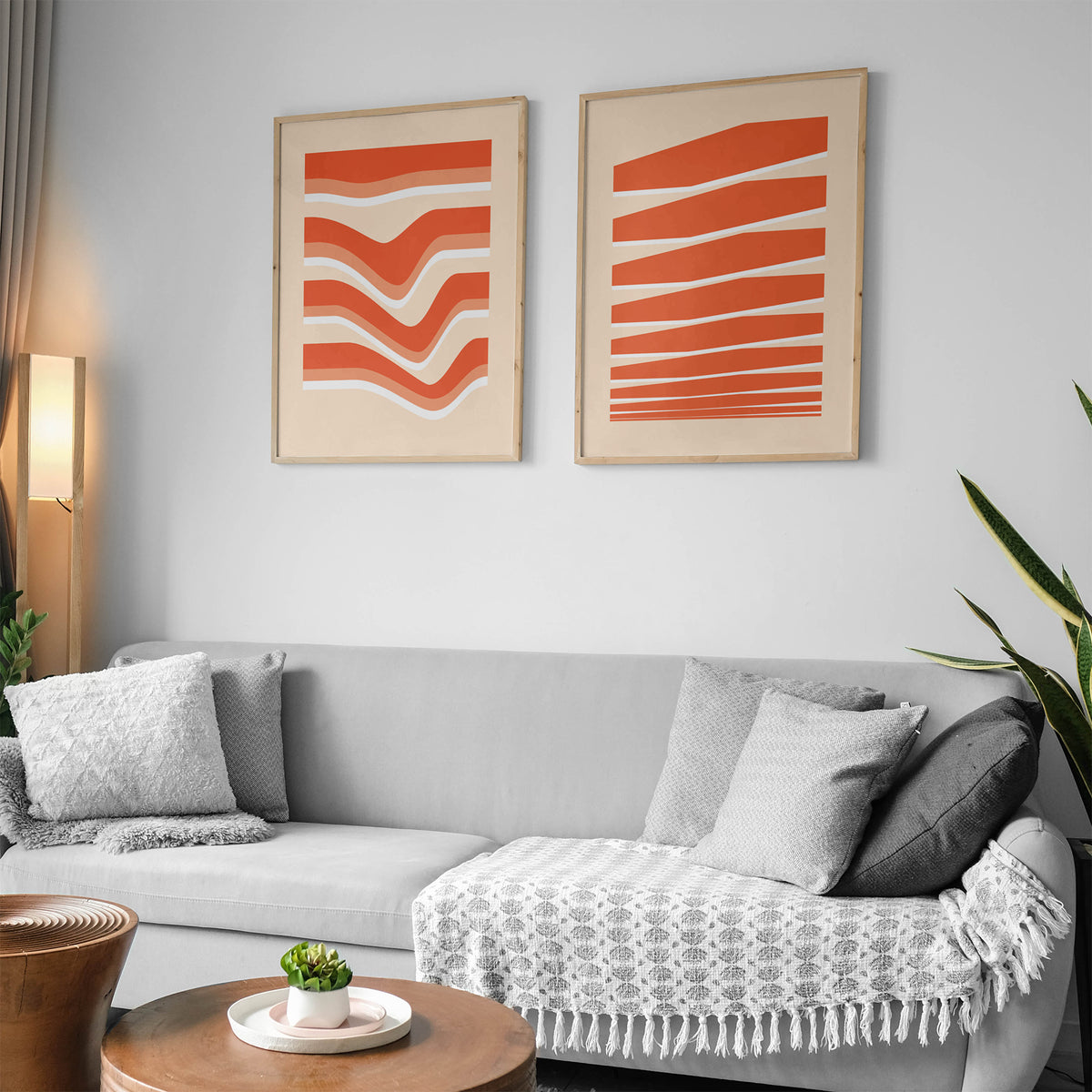 Two Wall Posters Povetrie with orange lines and shapes on the wall in a living room