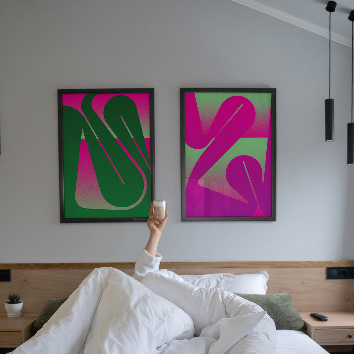 set of Interior prints in with a curved line in green and pink in black frames in a bedroom