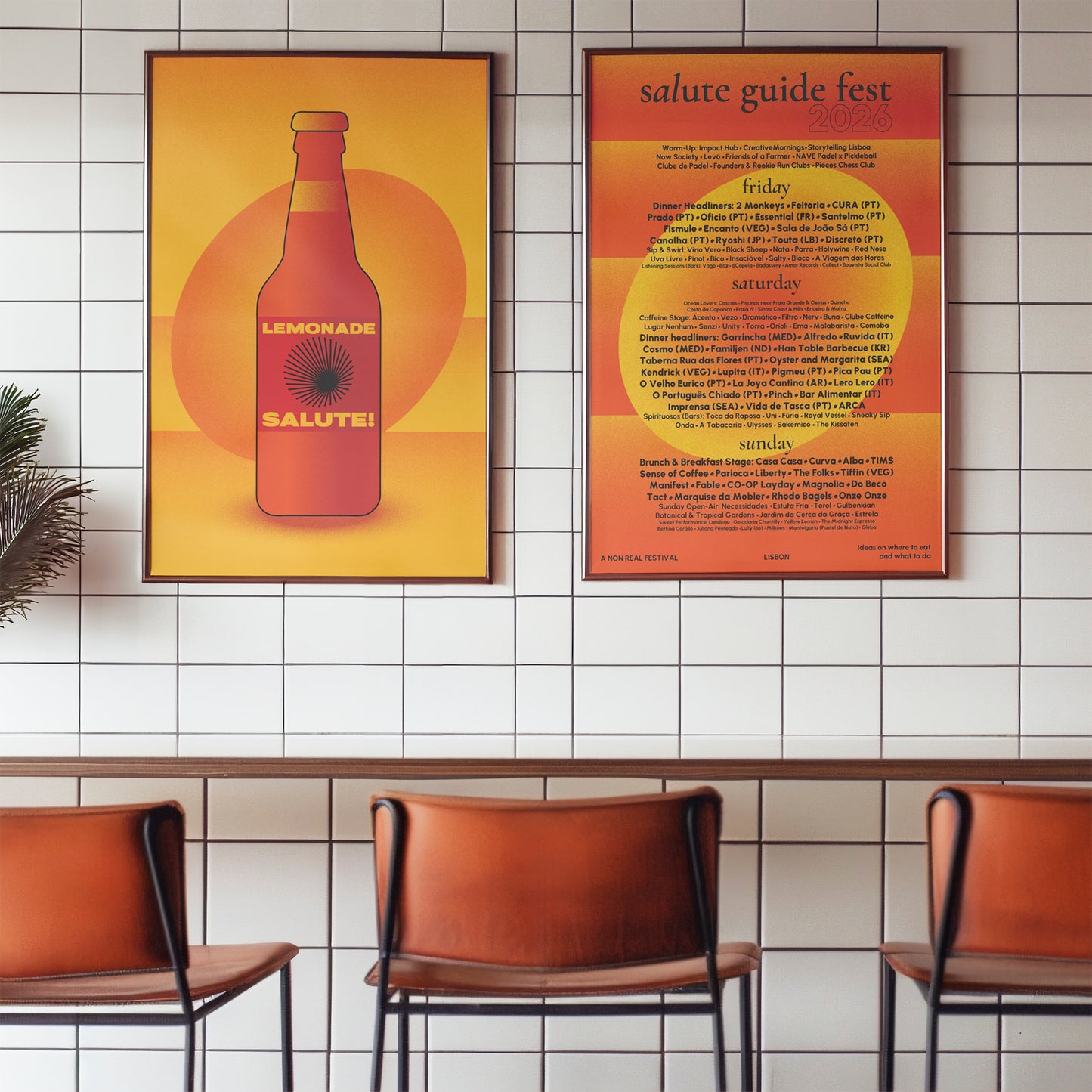 Two framed art prints hang on a white tiled wall above a row of brown leather chairs. The left print features a retro orange and yellow lemonade bottle illustration with the text 'LEMONADE SALUTE!'.