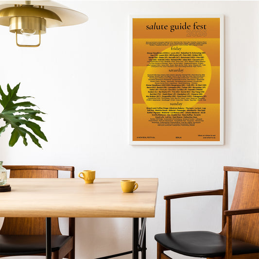 Interior Poster Salute guide fest in yellow-gold about Berlin on the white wall in a living room