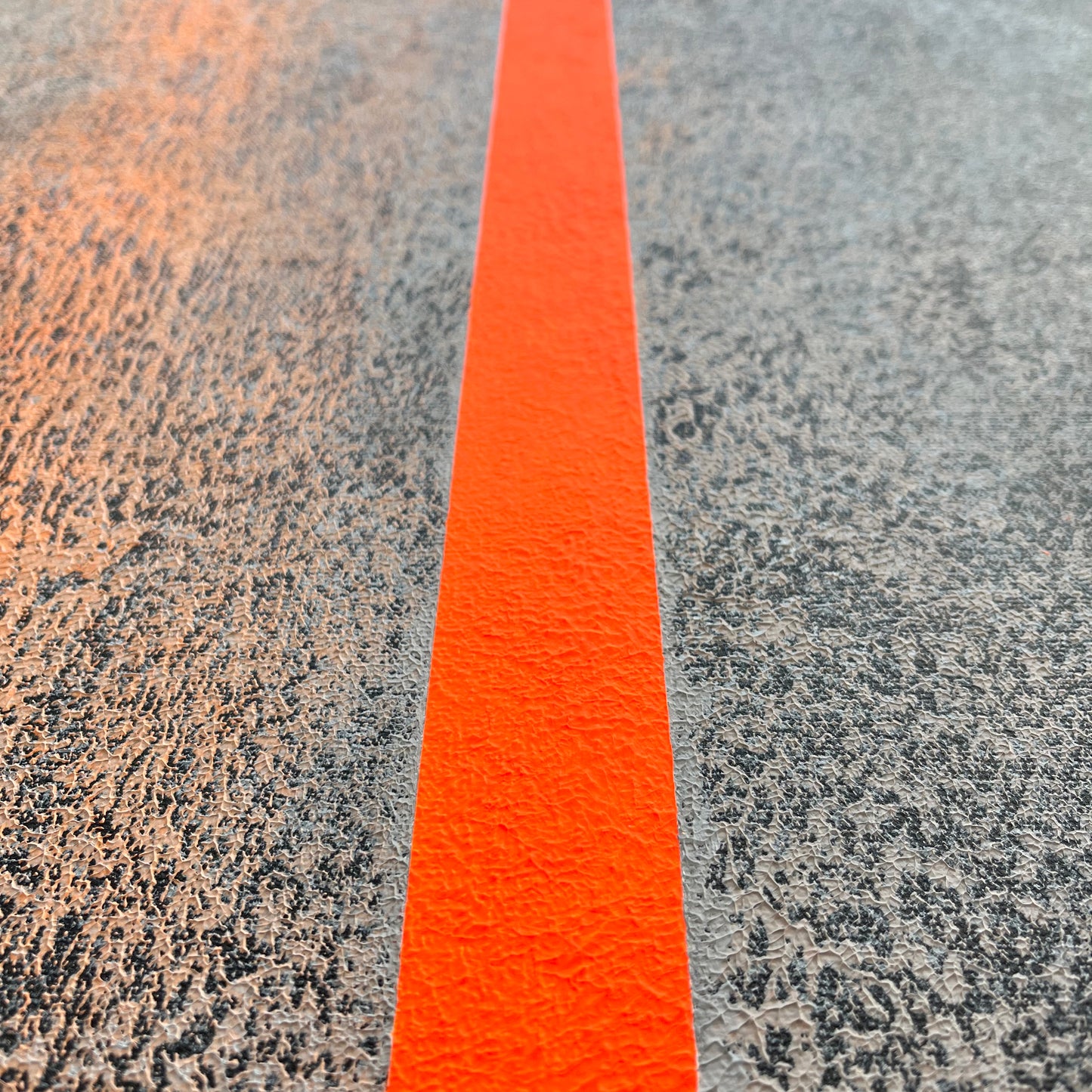 Abstract interior canvas with black background, gray texture and bright orange line close up