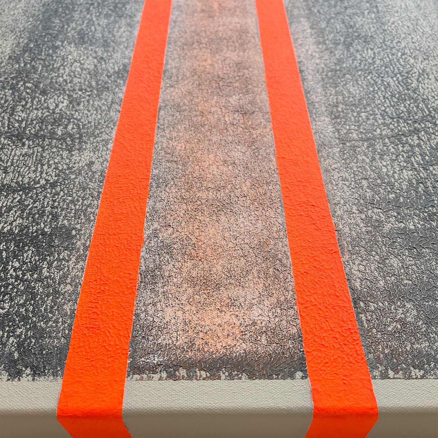 Abstract beige-gray canvas with 2 orange lines close up