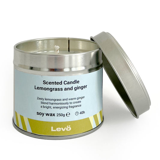 Scented candle in a metal tin labeled 'Levo' with lemongrass and ginger fragrance.