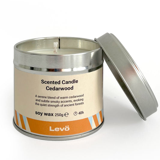 Scented candle in a metal tin labeled 'Levo Cedarwood' on a white background