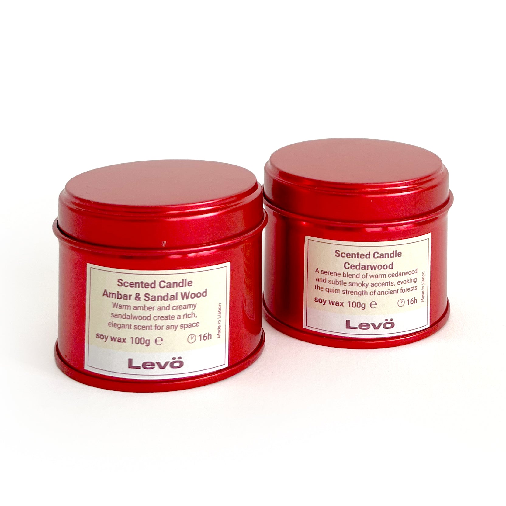 Two red tins of scented candles with labels on a white background