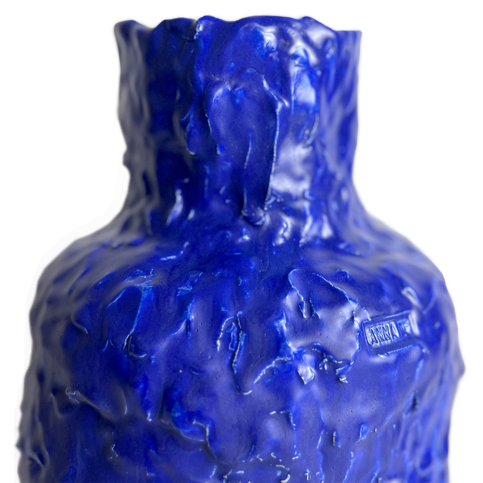 Blue textured glass bottle with 'Rocca' branding on a white background