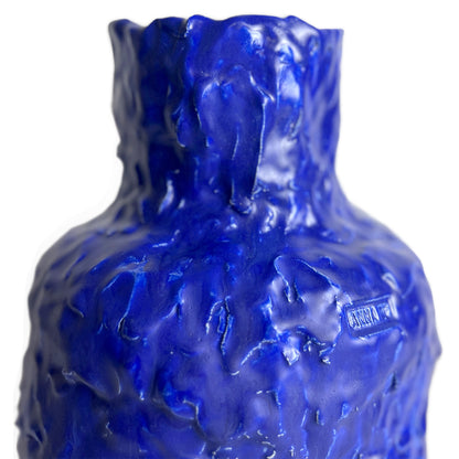 Blue textured glass bottle with 'Rocca' branding on a white background