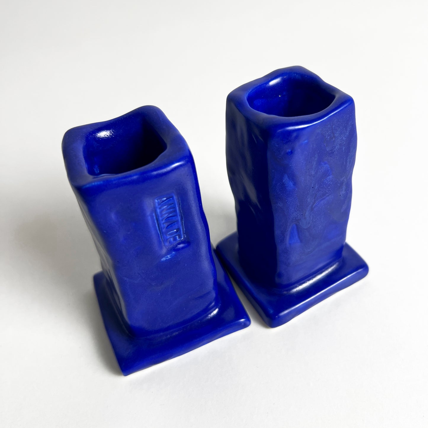 Two blue ceramic candle holders on a white background