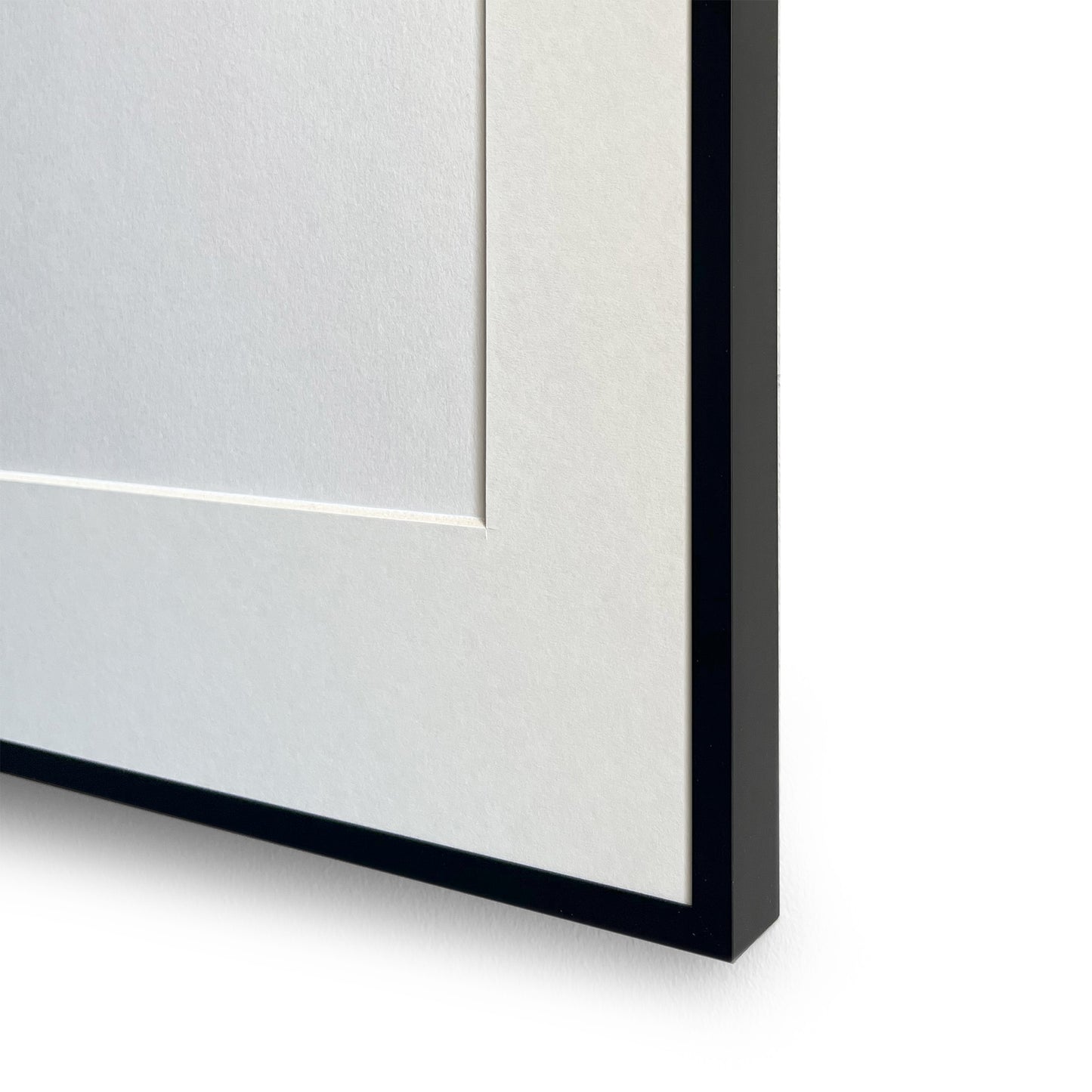 Close-up of a black aluminium picture frame corner on a white background