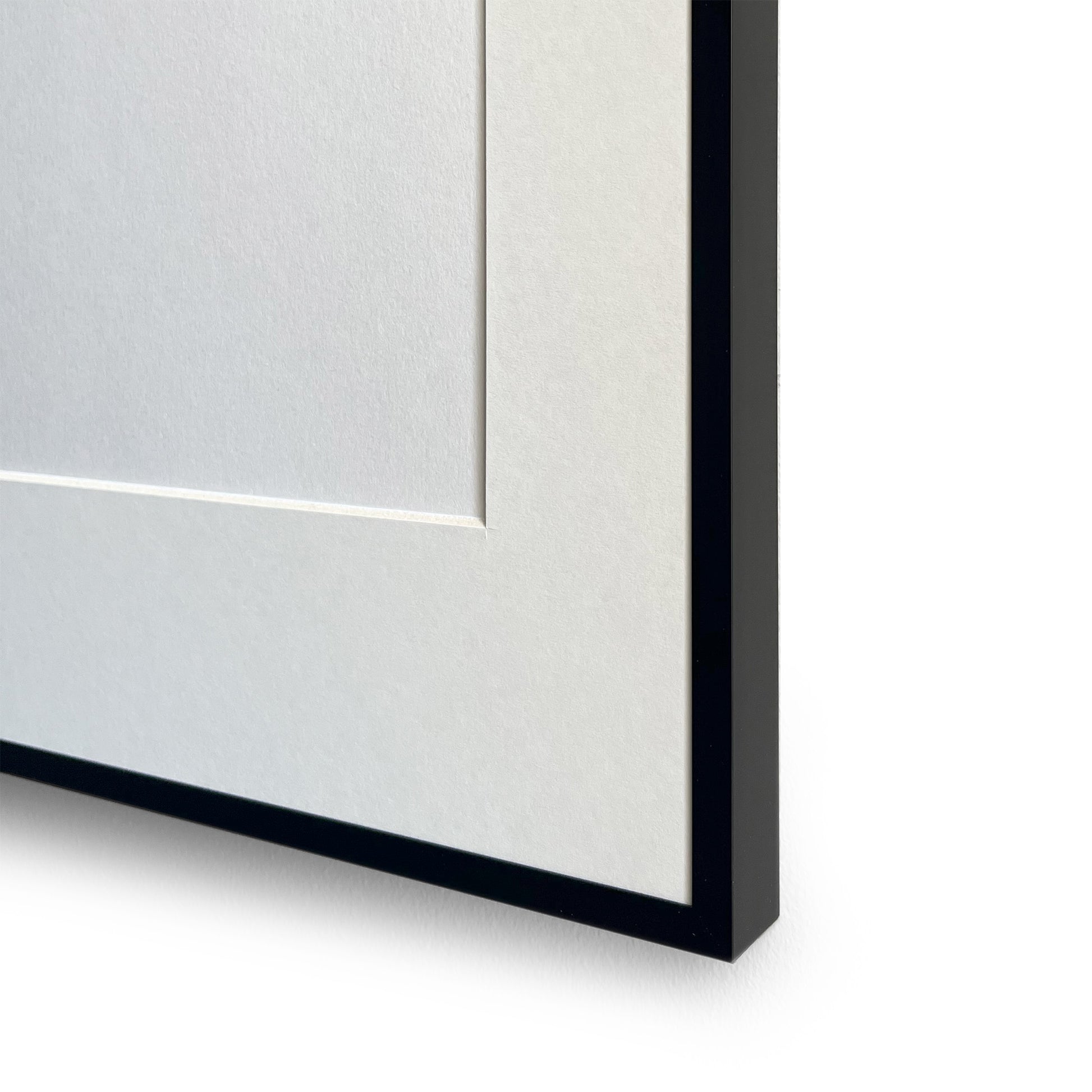 Close-up of a black aluminium picture frame corner on a white background