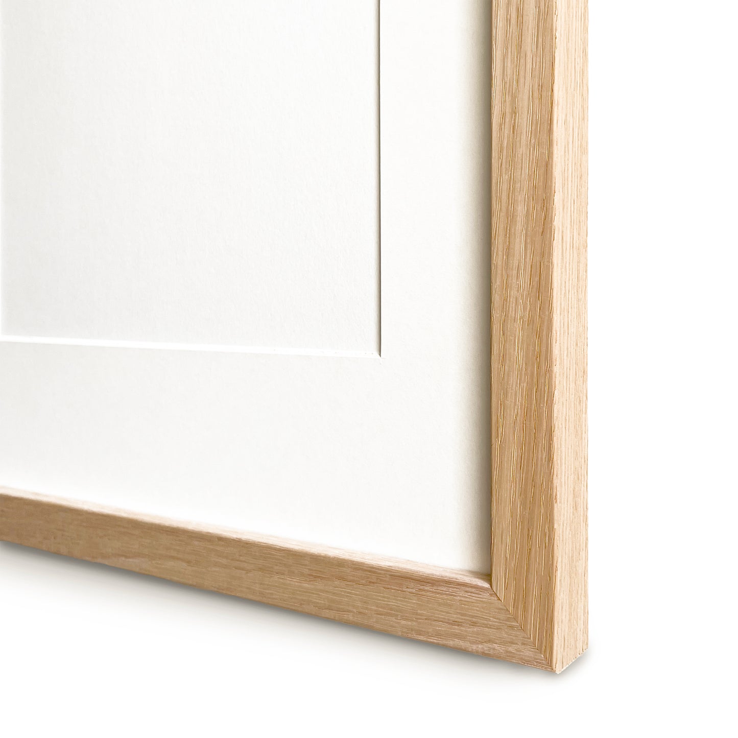 Close-up of a light wood picture frame with pass partout corner on a white background