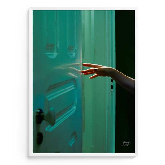 Photograhy art with hand reaching towards a teal door with a blurred background