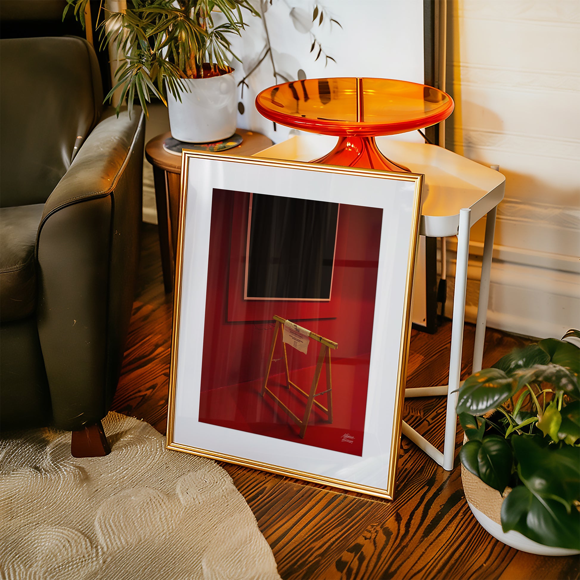 Framed abstract fine art photography on a wooden floor with a chair and plants in the background
