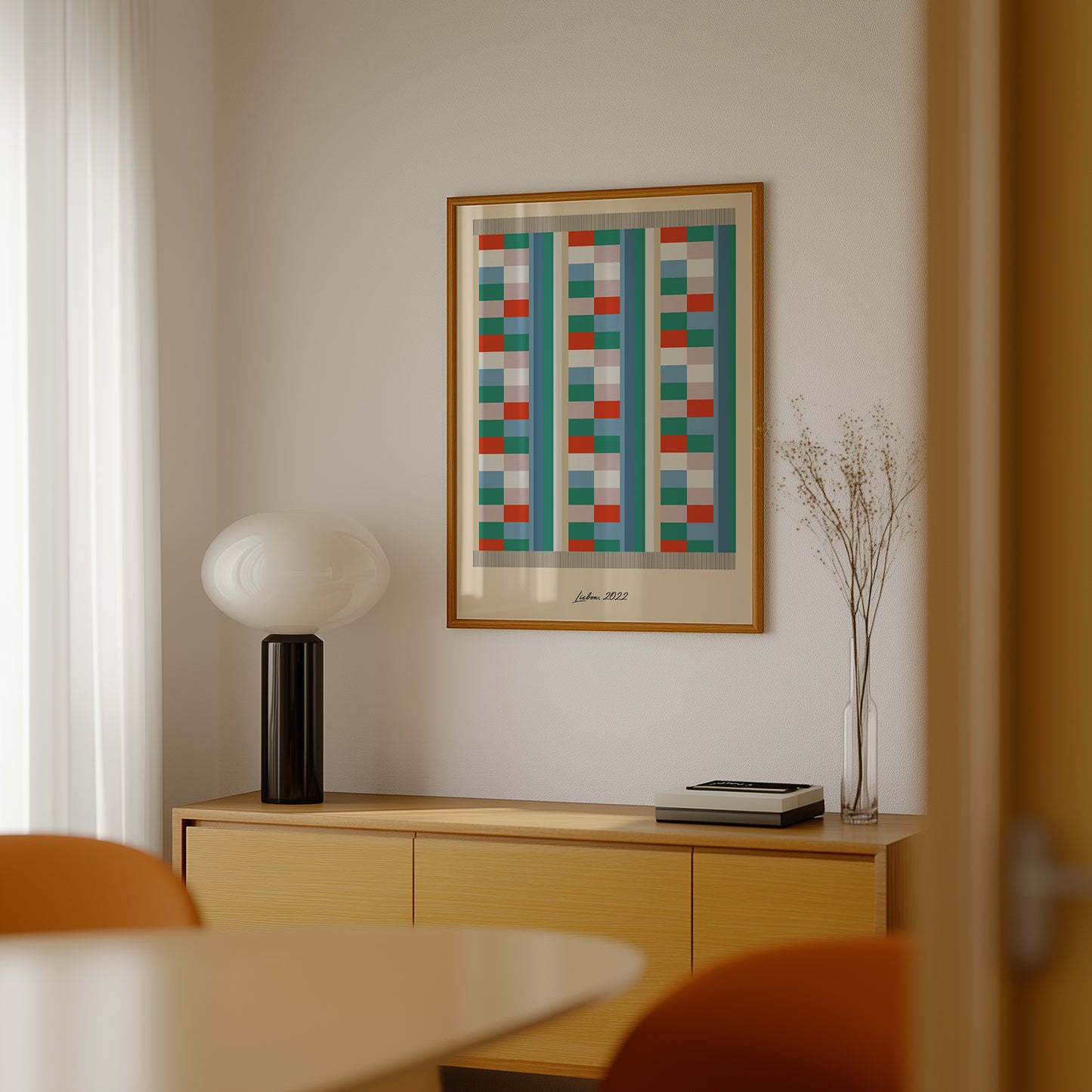 Framed geometric art piece on a wall above a wooden cabinet with decorative items.