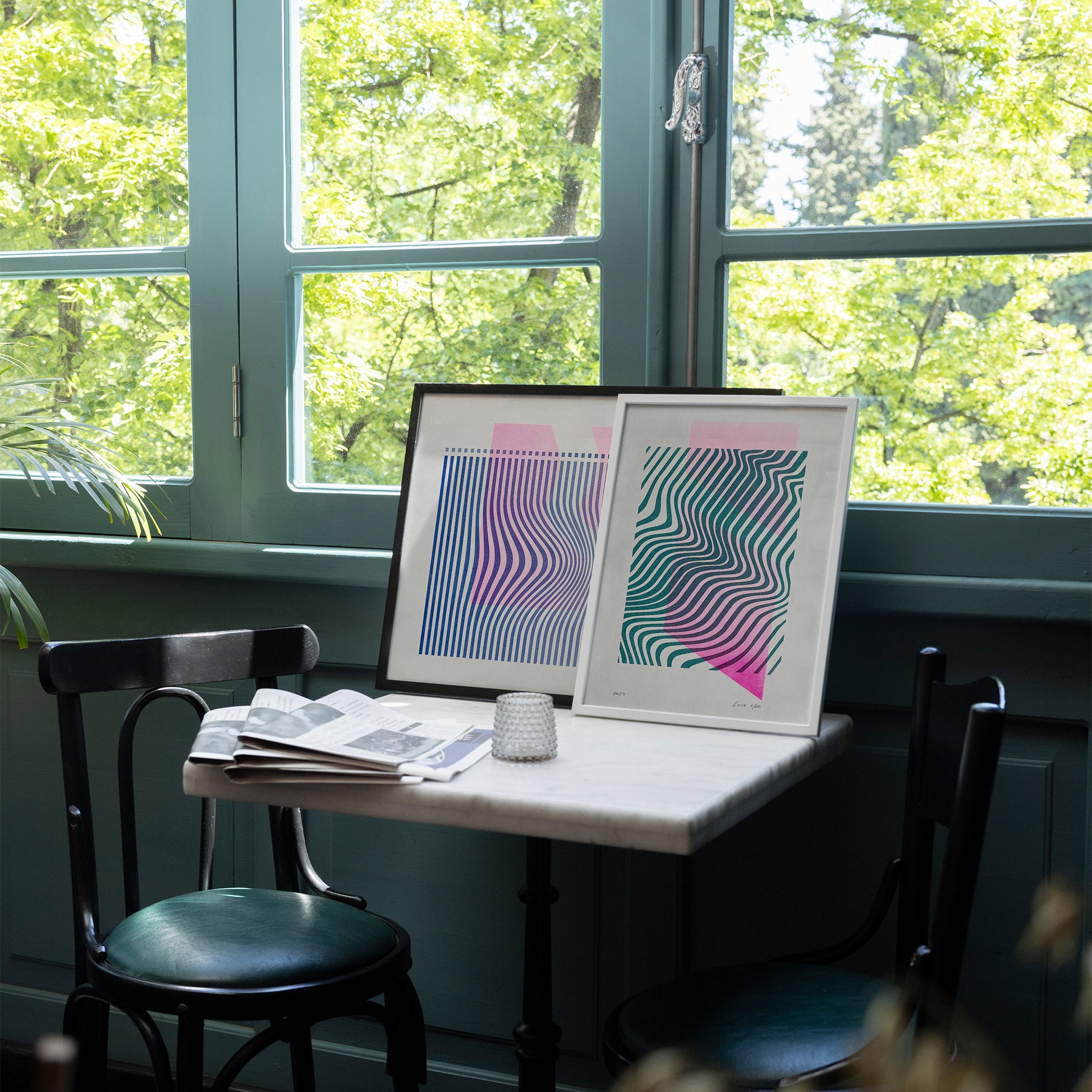 Limited edition posters Volna A4 and A3 on the table in a cafe