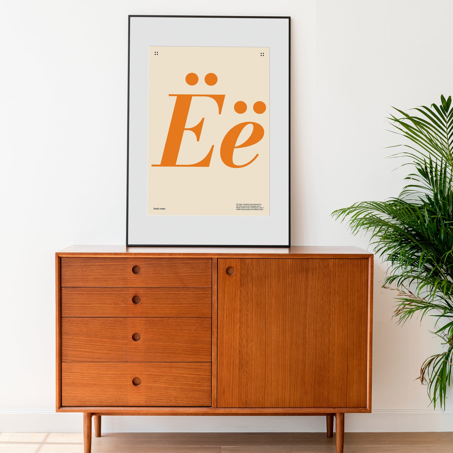 Poster with large orange letters 'Ë' and the inscription Details matter on a chest of drawers